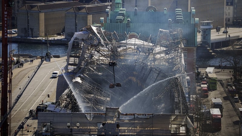 Firefighters spray water on the debris of the Boersen stock exchange