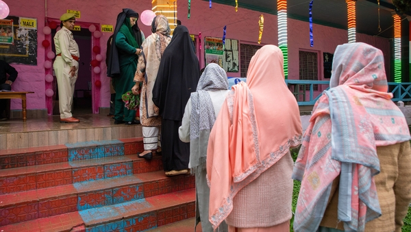 Women voters wait in a queue to cast their votes outside a polling station in Banihal, India