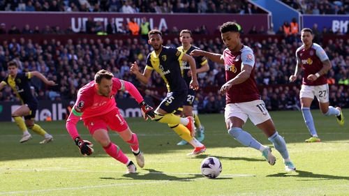 Ollie Watkins runs with the ball past Neto of Bournemouth