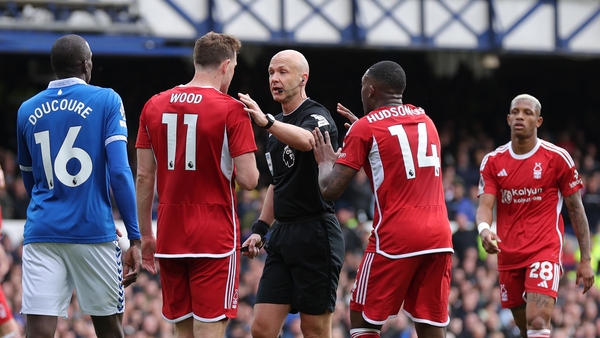 Referee Anthony Taylor is confronted by Forest duo Chris Wood and Callum Hudson-Odoi, claiming a hand ball against Ashley Young