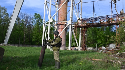 A member of the Ukrainian National Guard examines debris at the Kharkiv Television Tower which was destroyed by a suspected missile