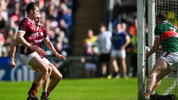 Liam Silke (L) and John Maher of Galway watch as Rory Brickenden of Mayo palms the ball off his own goalline