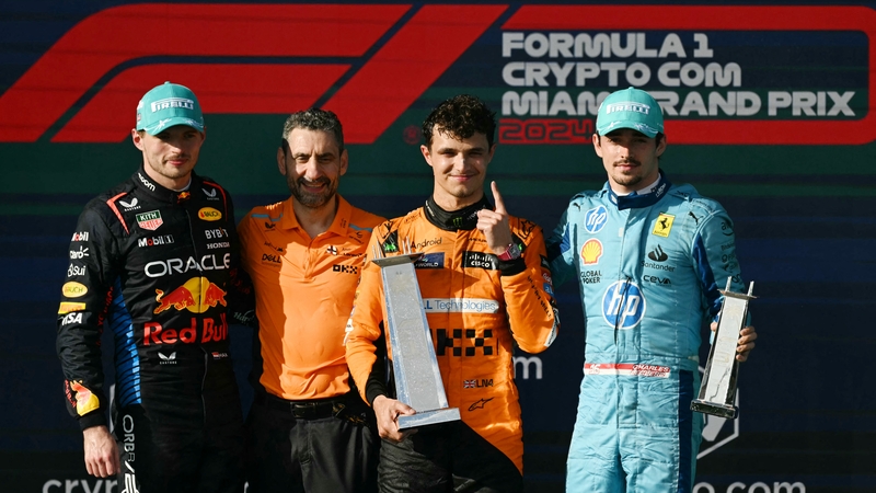 Lando Norris celebrates on the podium with Max Verstappen (L) and Chales Leclerc (R)