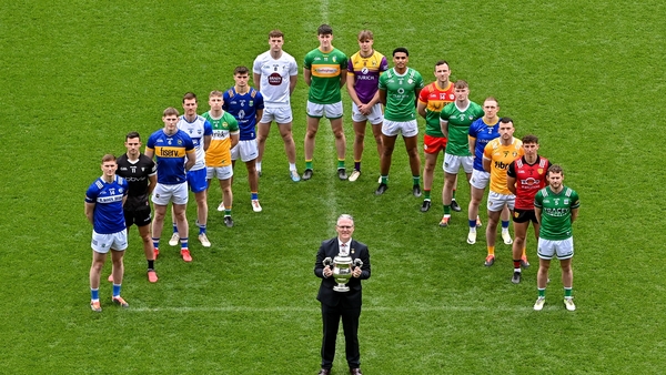 Jarlath Burns holding the Tailteann Cup with players from participating counties in the background