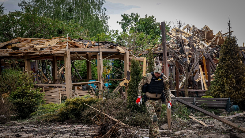 Ukrainian law enforcement officers work at the site of a Russian missile strike in the eastern Kharkiv region