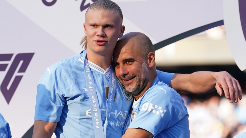 Manchester City striker Erling Haaland (L) and manager Pep Guardiola celebrate their title victory