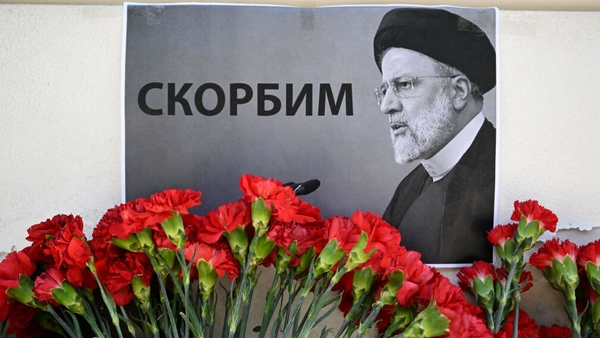 People bring flowers to the Iranian embassy to pay tribute to Iran's President Ebrahim Raisi