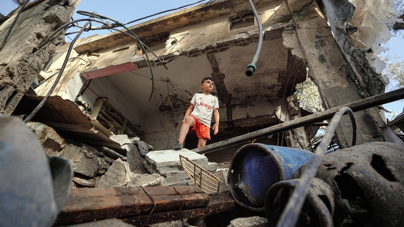 A boy stands amid the rubble of a house in Nuseirat destroyed by Israeli bombardment