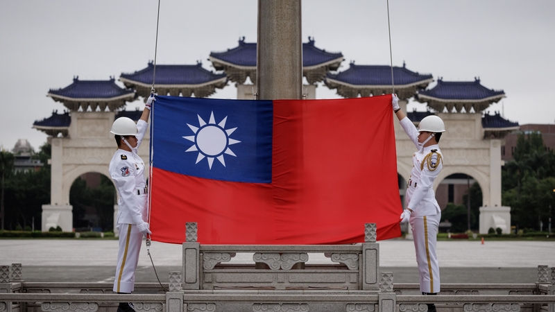 Bratach na Téaváine á tógáil sa phríomhchathair Tai-pei ar maidin inniu