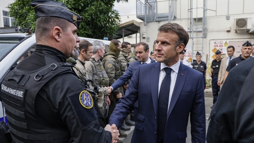 French President Emmanuel Macron visits the central police station with France's Minister for the Armed Forces Sebastien Lecornu (back L) in Noumea