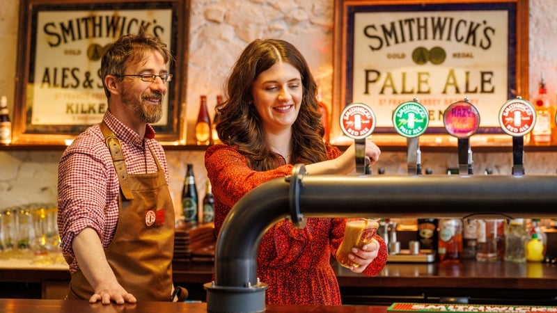 Smithwick's Experience Kilkenny Tour Guide Chris Hickey and visitor Alanna Henry, learning how to pull a pint of Smithwick's
