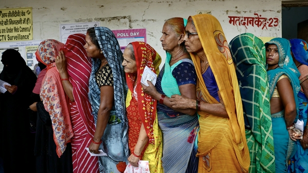 Women stand in a queue to cast their votes at a polling station in Saroi village, Bhadohi district in India's Uttar Pradesh state
