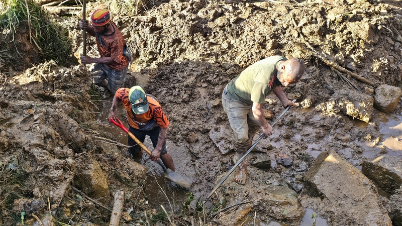 People dig through debris at the site of a landslide in Yambali village in the region of Maip Mulitaka in Enga Province, Papua New Guinea