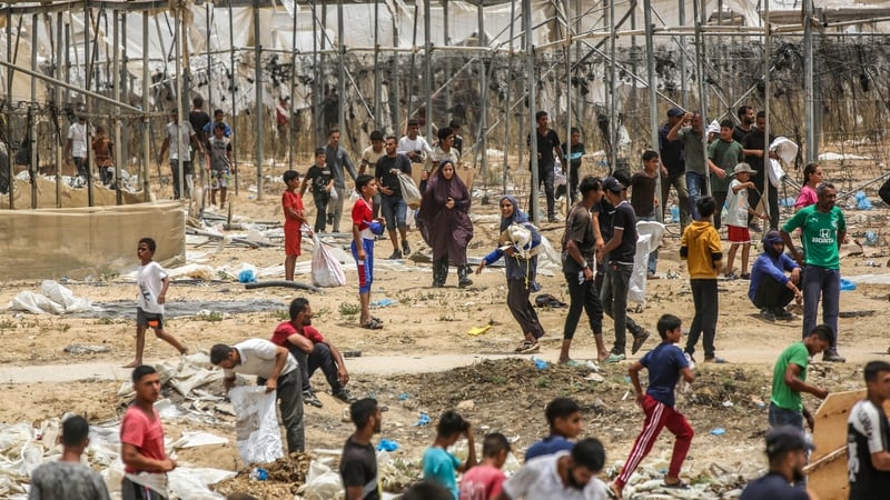 Palestinians gather to receive the humanitarian aid supplies that are airdropped by plane into the city of Khan Yunis, delivered by parachutes amidst Israeli attacks at Al-Mawasi, Gaza on May 28, 2024. Photo: Getty Images