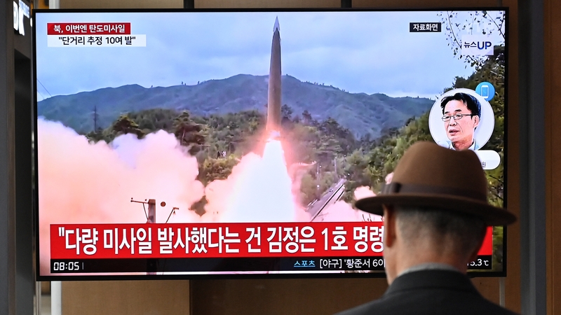 A man watches a television screen showing a news broadcast with file footage of a North Korean missile test, at a train station in Seoul