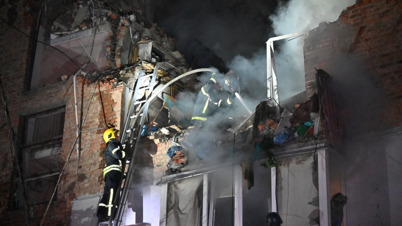 Rescuers extinguish a fire in an apartment building destroyed by a Russian missile attack in Kharkiv