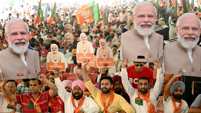 Supporters of the ruling Bharatiya Janta Party (BJP) hold cut-outs of Narendra Modi during an election campaign rally in Amritsar