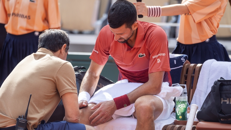 Novak Djokovic receives on-court treatment for his knee injury during his match against Francisco Cerundolo at the French Open