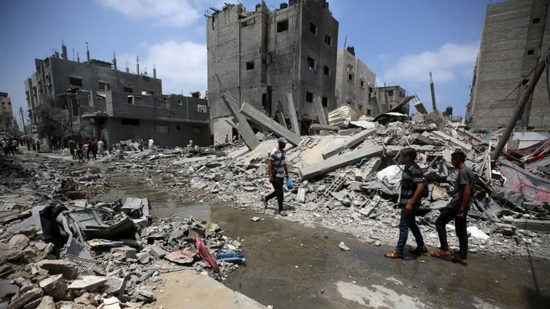 Palestinians are walking past debris a day after an operation by the Israeli Special Forces in the Nuseirat camp, in central Gaza