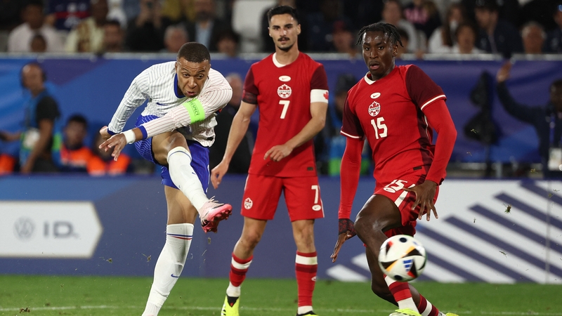 Kylian Mbappe (L) fires in an effort against Canada