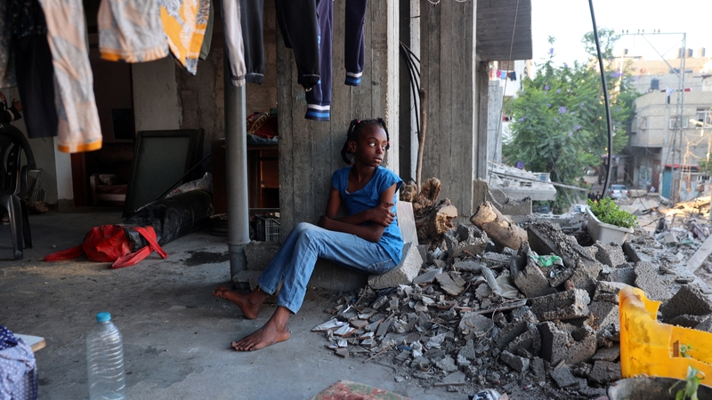A displaced Palestinian girl sits in a damaged building used as a temporary shelter in al-Bureij refugee camp in central Gaza
