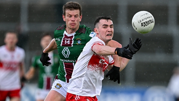 Diarmuid Baker of Derry battles Westmeath's John Heslin for possession