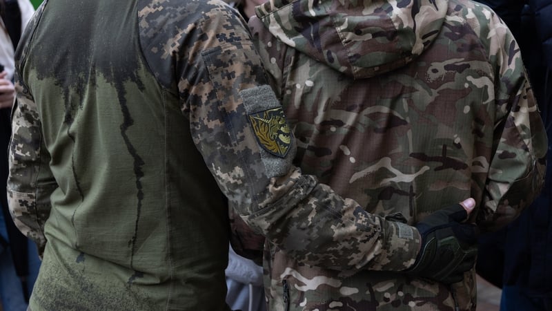 Military members of the LGBT community hug during the Kyiv pride parade