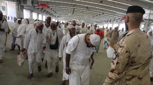 An officer spraying water on a man during a hot day as Muslim pilgrims on the annual Haj pilgrimage in Saudi Arabia