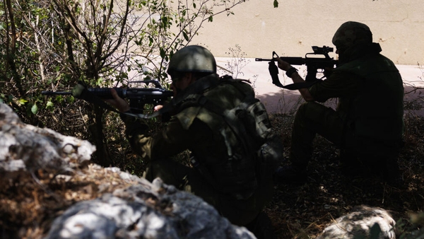 Israeli soldiers keep watch near the border with Lebanon after a Hezbollah attack