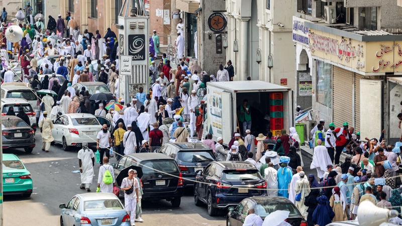 Departing pilgrims waiting along a road in the city of Mecca