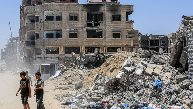 Palestinians go about their daily lives in Khan Younis among the rubble of buildings