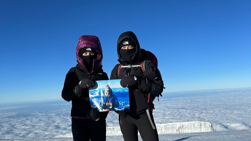 The sisters posed with a photo of their father at the same place on the summit of Mt Kilimanjaro