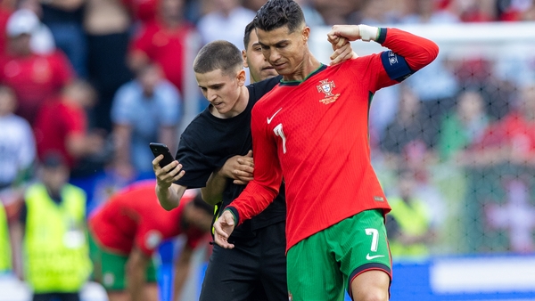 A pitch invader takes a selfie with Cristiano Ronaldo during Portugal's win over Turkey