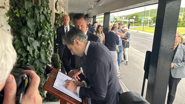 Simon Harris signing the book of condolences