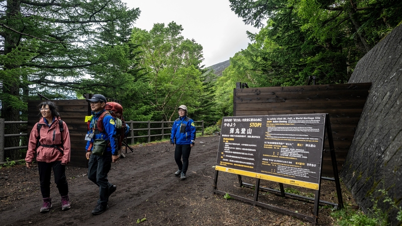 Hikers walk out from the newly-built trail gate at Fuji Subaru Line 5th station, which leads to the popular Yoshida trail to climb Mount Fuji