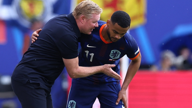 Netherlands' head coach Ronald Koeman (L) speaks with Netherlands' Cody Gakpo during the win over Poland