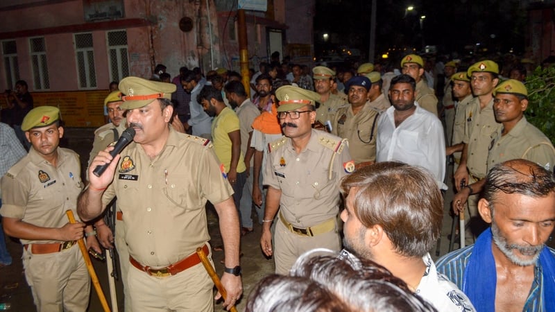 Police are seen outside a hospital where mourners have gathered in Hathras in India's Uttar Pradesh state