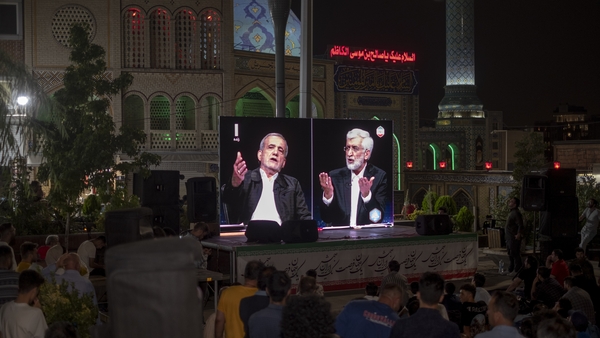 Iranian presidential candidates reformist Masoud Pezeshkian and hardliner Saeed Jalili are seen on a street display during a live televised debate