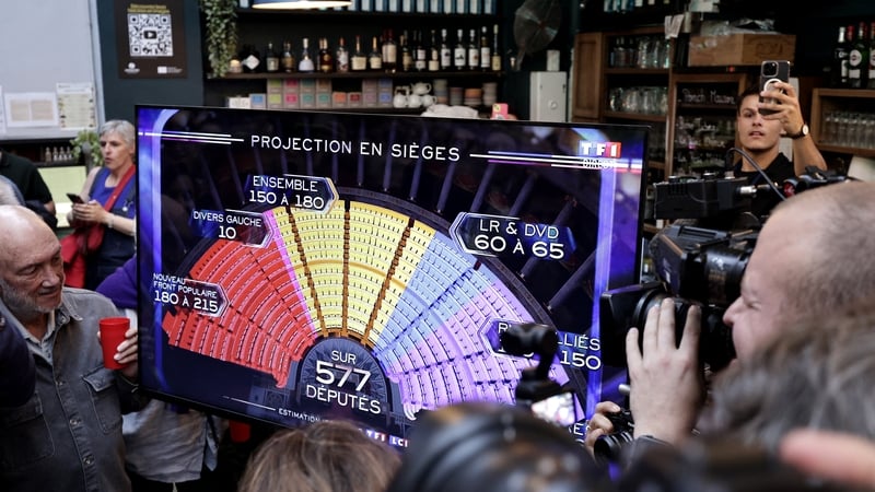 Supporters of the French left wing Socialist Party (PS) watch a screen displaying the first results of the second round of France's legislative election