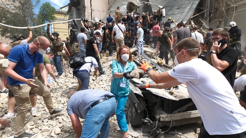 People clear rubble at the Okhmatdyt children's hospital after the missile strike
