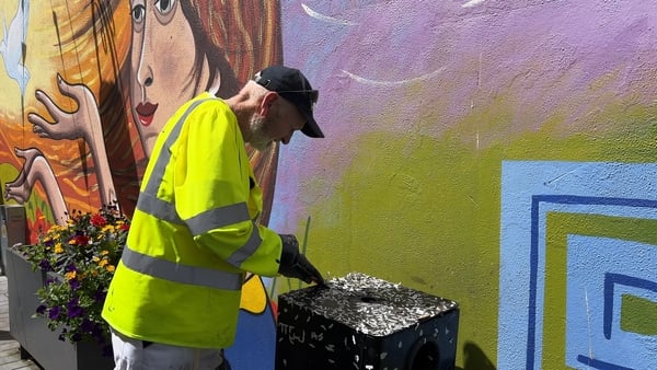 Tony O'Neill of Clonmel Borough District uses a scraper and sandpaper to clean the bins
