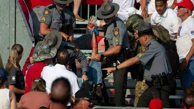 A person at the rally is helped to safety after being injured in the shooting