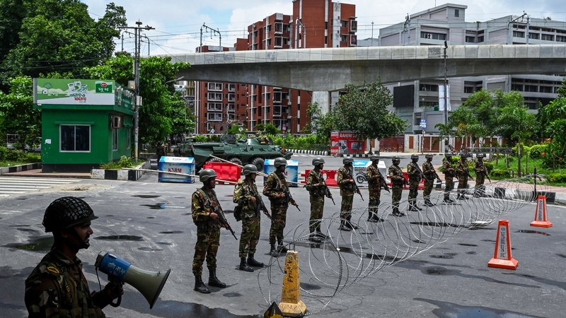 Bangladesh army personnel stand guard near the parliament house amid a curfew following clashes between police and protestors