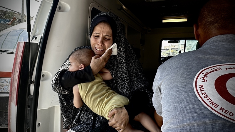 An injured woman holds her baby as they are brought to Nasser Hospital after an Israeli attack in Qizan an-Najjar, Khan Younis