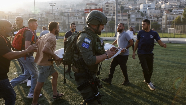 Israeli security forces and medics carry the injured towards waiting ambulances following the attack on Israeli-occupied Golan Heights on Saturday