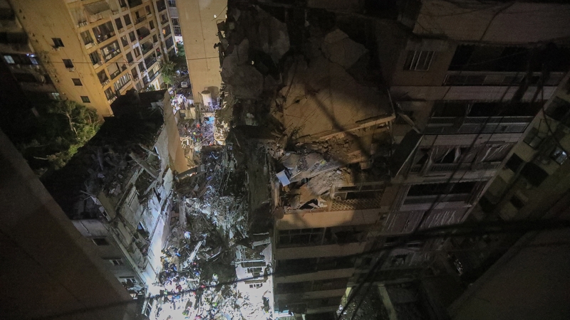 A view of the destroyed building as security forces and health care crew arrive in the site after an explosion occurred in the Dahieh area of Beirut, the capital of Lebanon