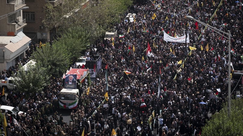 A truck carrying the coffins containing the bodies of Hamas leader Ismail Haniyeh and his bodyguard Abu Shaaban makes its way through the crowd in Tehran