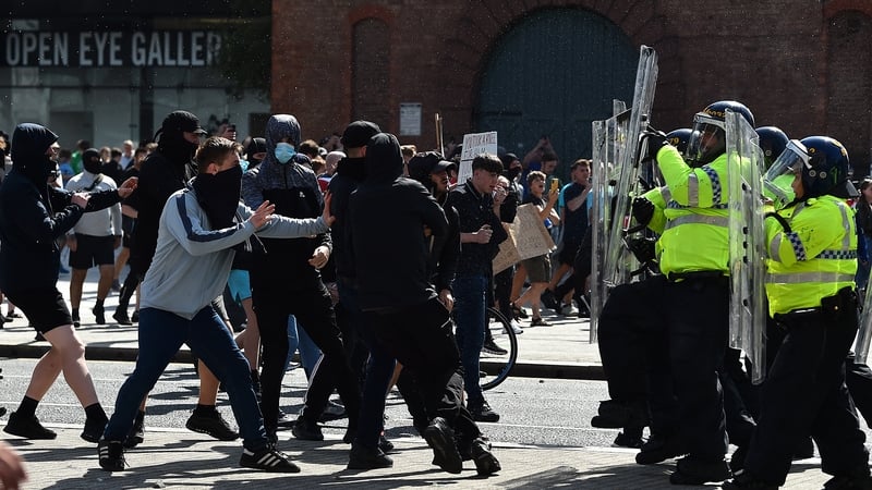 Police officers face protesters outside the Liver Building in Liverpool