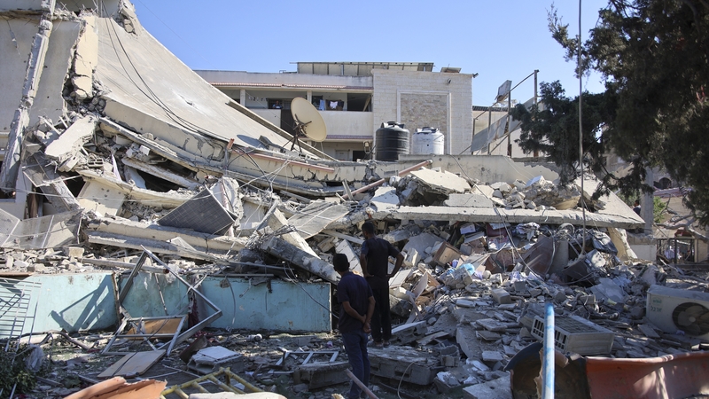 People inspect the damage following Israeli bombardment on the Al-Nassr school that houses displaced Palestinians