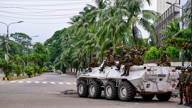 Bangladesh army personnel stand guard during a curfew following clashes between police and protesters